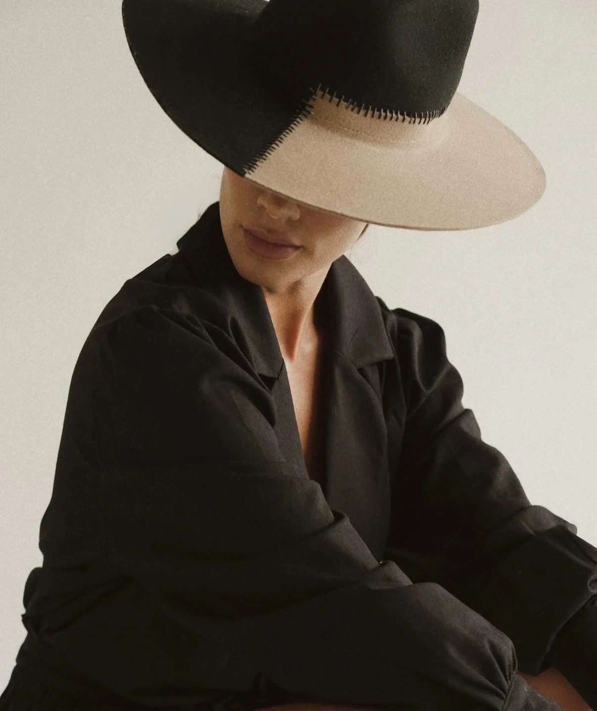 Modelo con Signature Hat bicolor de ala ancha cubriendo el rostro