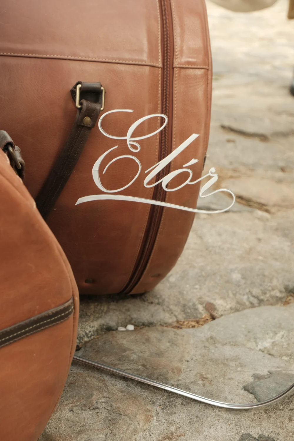 Firma ELÓR en acrílico sobre un baúl de cuero cognac del atelier itinerante