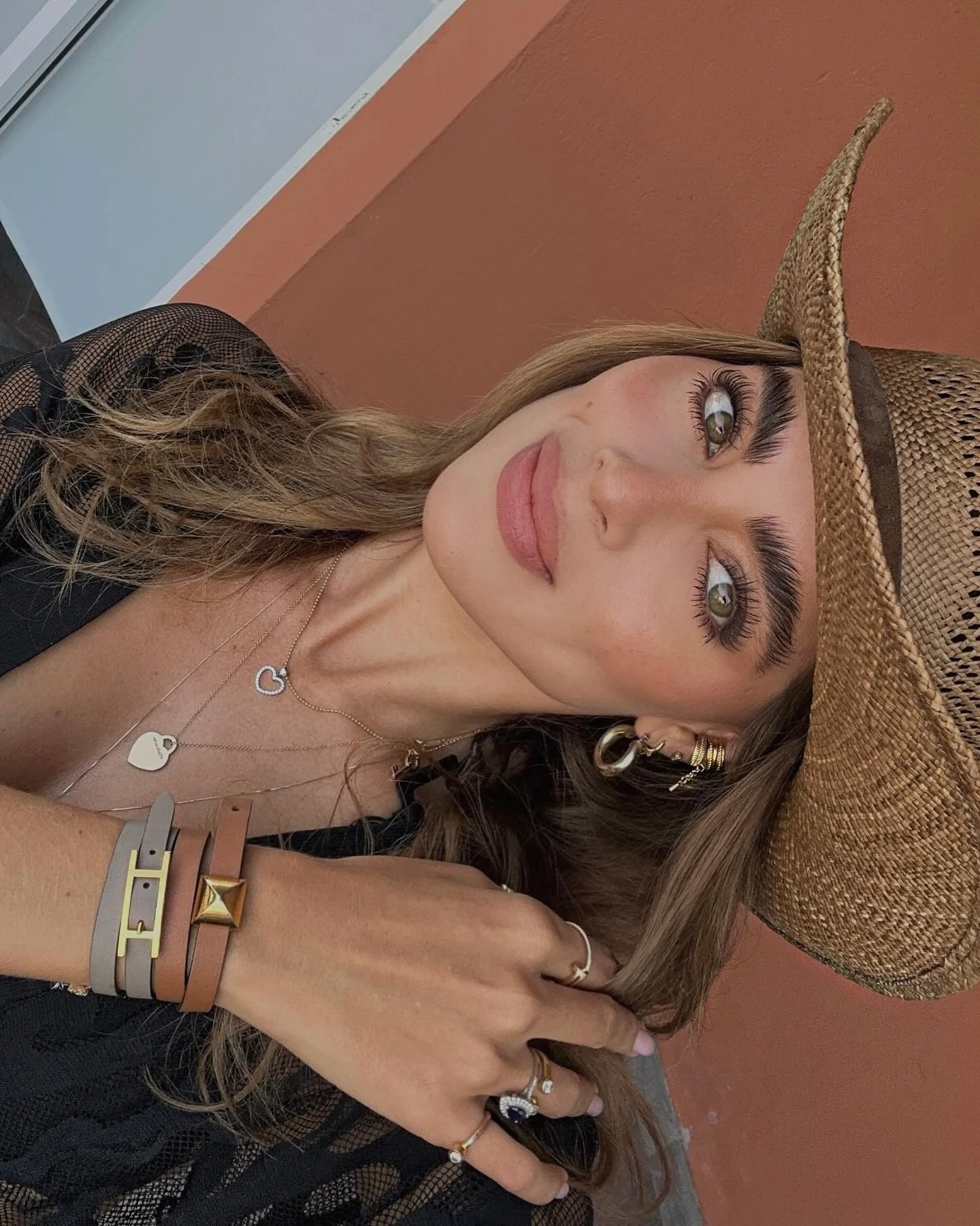 Retrato con sombrero de gamuza tan y vestido negro al atardecer
