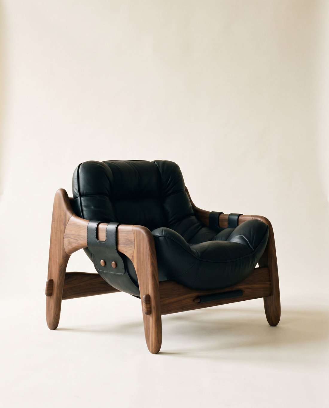 MONTURA, butaca de madera maciza con cojines de cuero negro colgados de correas, retrato de estudio