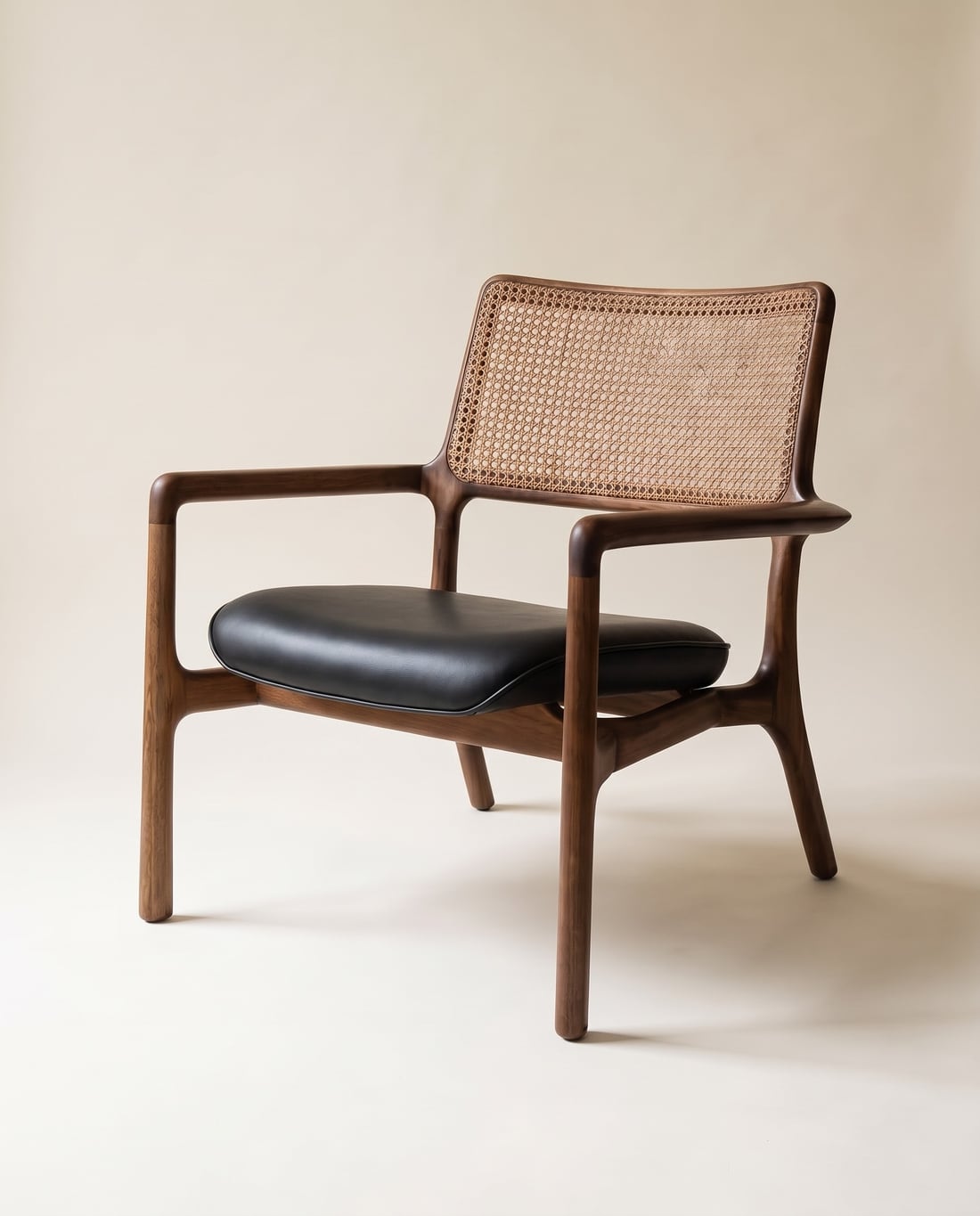 MONTANA CHAIR de madera maciza con espaldar en mimbre tejido y asiento en cuero negro, retrato de estudio